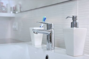 Beyaz banyo Sabunluk ve diş fırçaları cam lavabo.