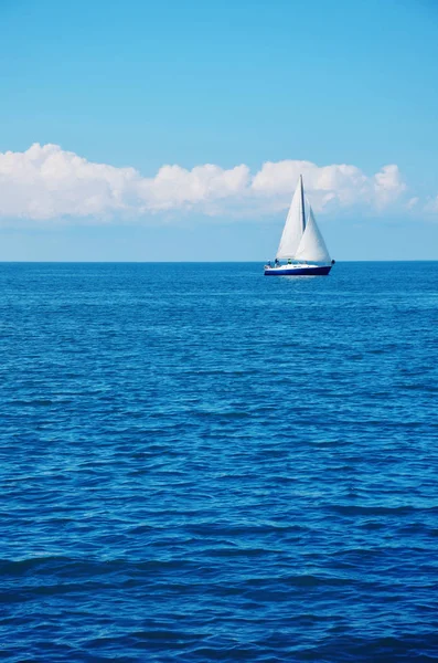Agua de mar azul y un velero blanco . —  Fotos de Stock