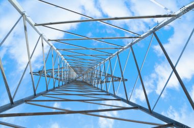 Beyaz bulutlu mavi gökyüzüne bakan uzun metal bir yapıya bakın. Metal mimari detaylarıyla soyut arkaplan.