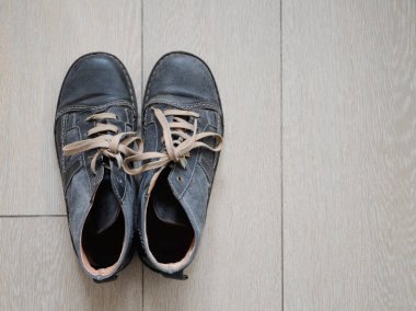 Bir çift iyi giyimli, kot pantolonlu, gri deri çizme ve ahşap zemine güzel dikişler. Boş alanı olan üst görünüm.