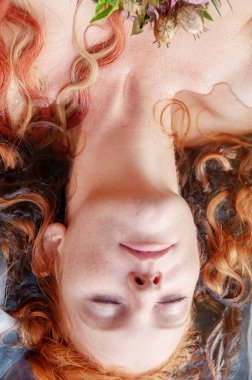 Göldeki su ölmek Ophelia gözlü çiçeklerle yalan kıvırcık kırmızı saçlı güzel güzel portre genç bir seksi kadın kapalı