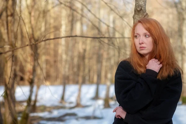 Junge sexy Frau mit roten Haaren, schwarzer Kleidung, steht traurig, deprimiert, verzweifelt im Wald — Stockfoto