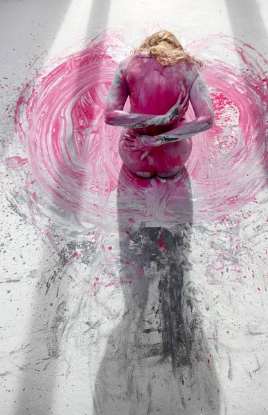 Parte de trás de uma jovem mulher nua em rosa, cinza branco, cor, pintado, sentado no chão do estúdio Artistas em cores. Arte corporal expressiva criativa e abstrata — Fotografia de Stock