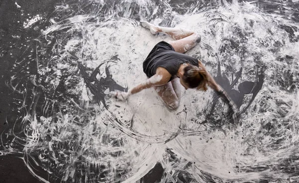 Νεαρή γυναίκα χορεύει στο πάτωμα κομψά διακοσμητική, σε γκρι και λευκό χρώμα. Δημιουργική, εκφραστική, αφηρημένη εκφραστική σωματική τέχνη και ζωγραφική. — Φωτογραφία Αρχείου