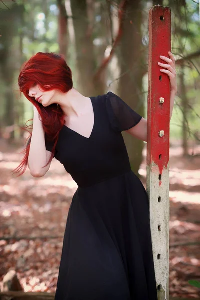 Jovem com cabelo vermelho em elegante vestido de noite na floresta — Fotografia de Stock