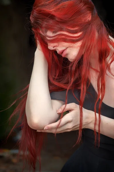 Porträt einer jungen Frau mit roten Haaren im eleganten schwarzen Abendkleid im Freien — Stockfoto
