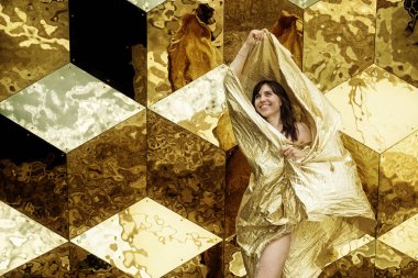 Altın Elbiseli Moda Mankeni, Kadın Güzellik Portresi, Altın Küp Arka Plan Önünde Altın Pırıltılı Kumaş Sallayarak