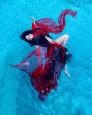 güzel genç kadın mutlu havuzda suda yüzen siyah ve kırmızı elbise rahat