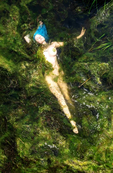 Giovane donna con i capelli blu alla deriva elegantemente nella palude — Foto Stock