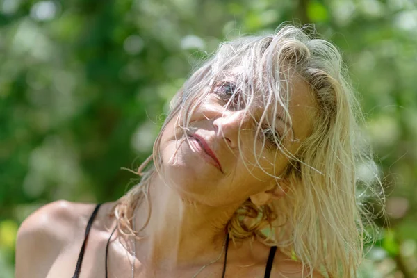 Šťastná žena středního věku s mokrými vlasy s úsměvem v lese — Stock fotografie
