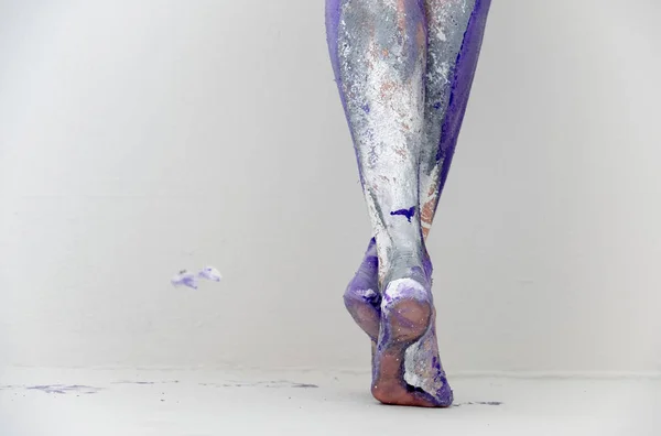 Krásné nohy a nohy mladé umělecky abstraktní malované ženy s bílou, šedou a fialovou barvou. Kreativní malba těla. — Stock fotografie