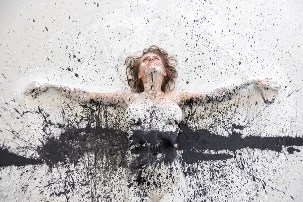 Portrait and arms of artistically abstract painted woman in black and white paint on the floor in studio. Creative expressive body painting art. — Φωτογραφία Αρχείου