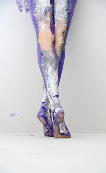 Belle gambe sexy e piedi di una giovane donna dipinta artisticamente astratta, ballerina con vernice grigia e viola. Pittura creativa di body art . — Foto Stock