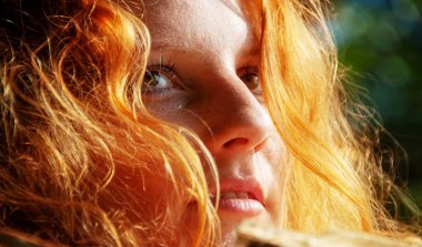 Güzel, şehvetli bir portre. Düşünceli, genç ve seksi bir kadının. Kızıl saçlı, uzun, kıvırcık saçlı, gün ışığında.