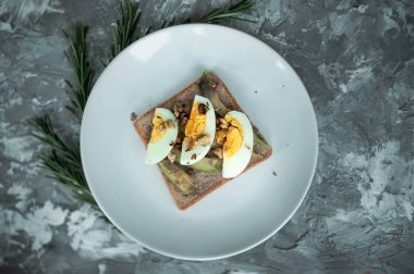 Çavdar ekmeği, dilimlenmiş avokado, fındık ve yumurta ile kahvaltı veya öğle yemeği için sağlıklı avokado tost. Vejetaryen sandviçler. Bitki bazlı diyet. Tüm gıda konsepti.