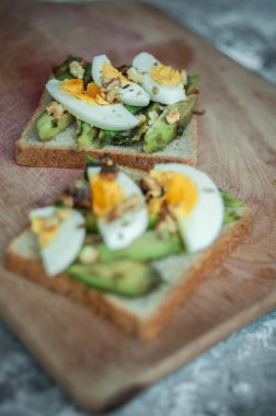Avokado ile tost ve rustik ahşap arka plan üzerinde yumurta