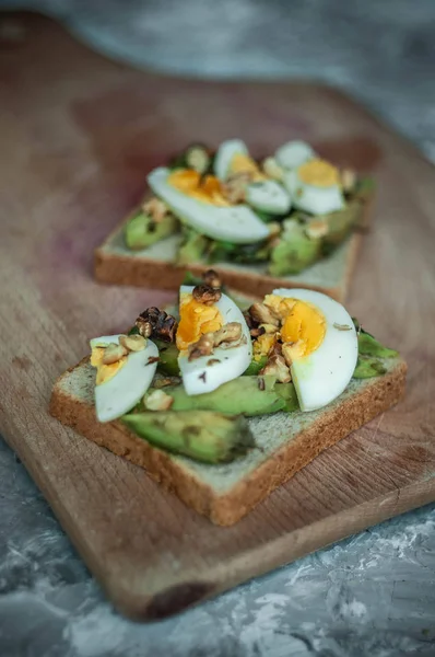 Avokado ile tost ve rustik ahşap arka plan üzerinde yumurta