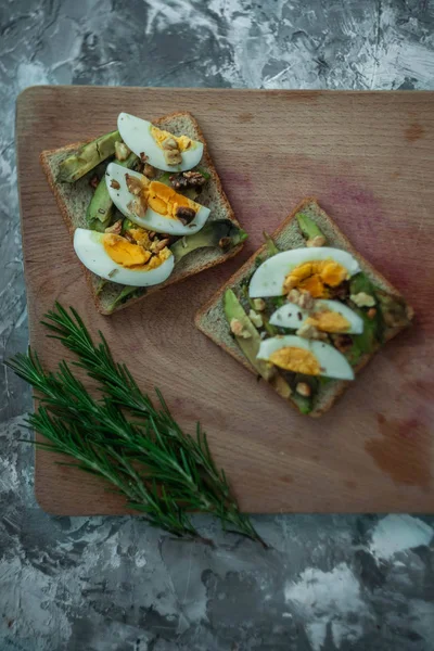 Avokado ile tost ve rustik ahşap arka plan üzerinde yumurta