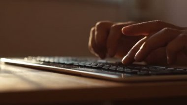 Klavyede daktilo, modern ofis işleri. Kapalı alanda gün batımında klavyede erkek eli izi var. Bilgisayarda çalışan bir iş adamı. E- posta, kodlama, internette sörf