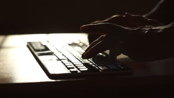 Klavyede daktilo, modern ofis işleri. Kapalı alanda gün batımında klavyede erkek eli izi var. Bilgisayarda çalışan bir iş adamı. E- posta, kodlama, internette sörf — Stok video