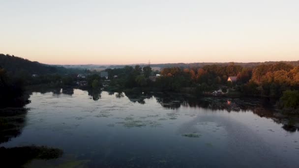 Flygfoto över landskapet på sommaren. Tallskog och gul höstskog. Soluppgång, gryning, dimmig tidig morgon i en liten fiskeby. Vacker flodvik eller sjö — Stockvideo