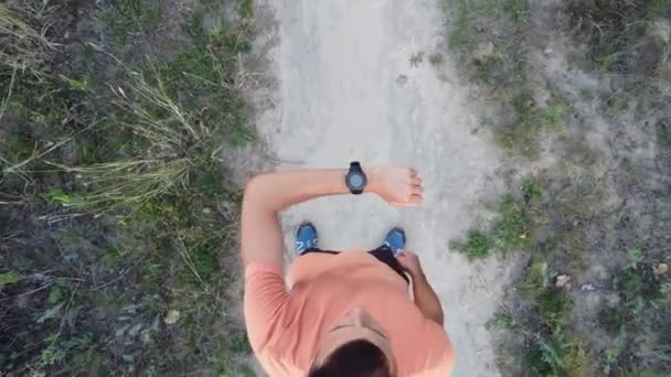 Atleta registra as leituras de pulseira fitness. Homem usando relógio inteligente Dispositivo de pulseira vestível. Corredor começando relógio inteligente temporizador e correndo. A verificar o pulso no Smartwatch. Filmagem aérea vista superior — Vídeo de Stock