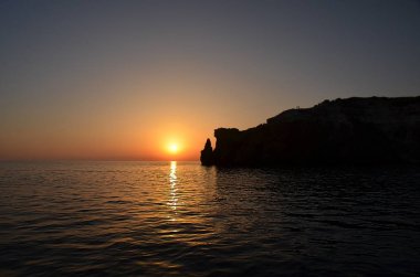gün batımı denizin, gece geliyor ve temizleyin siluetleri dağ ve iki kişi üzerinde duran