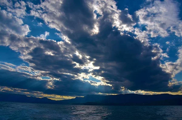 o güneş ışınları deniz ve kayalar aydınlatıcı bulutların arasından kırdı. Kırım'da, Karadeniz kıyısında