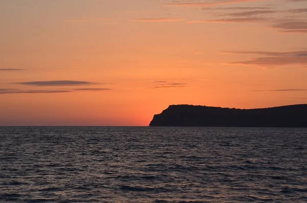 Kırım'da, dağın üzerinden günbatımı yumuşak kızdırma. Dağ silueti ufukta contrastingly görülür. Karadeniz onun adına karşılık gelen.