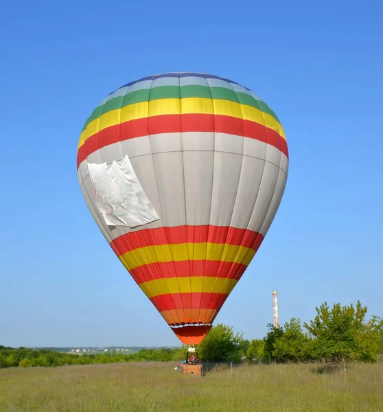 soft, precise landing of the balloon, after flying in the blue, cloudless sky, at the same time about twenty balloons