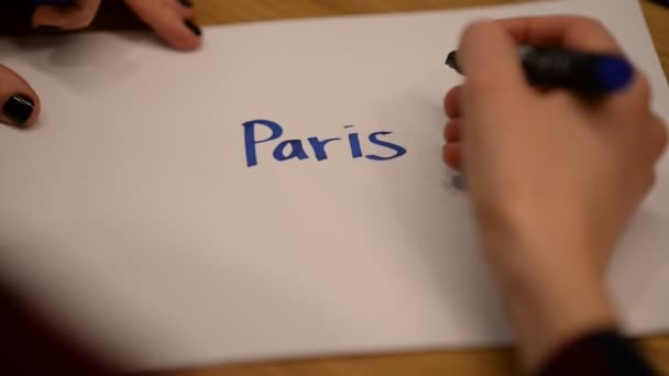 Mão Uma Jovem Rodeia Inscrição Paris Com Marcador Azul — Vídeo de Stock