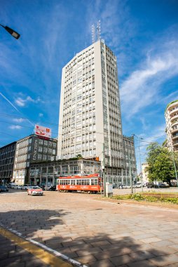 Milan mı? İtalya - 21 Mayıs 2019: Milano 'daki Street Piazza della β bblica' daki High Building. Binanın yanındaki kırmızı tramvay..