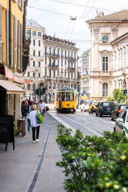 Milan mı? İtalya - 21 Mayıs 2019: Old Yellow MIlan Tram. Güneşli bir günde yayalar ve arabalarla sokak panoraması.