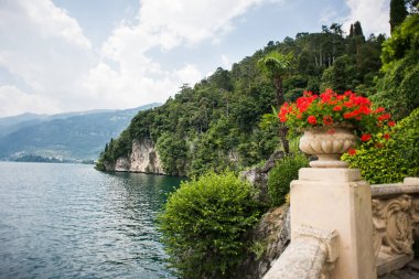Villa Balbianello 'da. Como Gölü. İtalya - 19 Temmuz 2019: Como Gölü üzerindeki çarpıcı manzara. İtalya. Villa del Balbianello Parkında Çiçekli Taş Vazo. 
