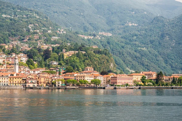 イタリアのコモ湖のメナジオ町のパノラマ カラフルな建物と明るい建築 観光客と都市銀行 水からの眺め — ストック写真