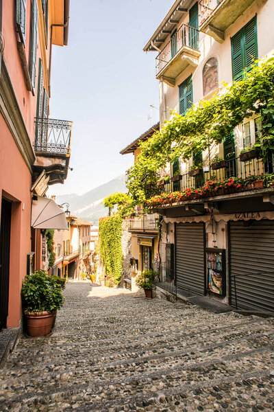 Bellagio. Lake Como. Italy - July 21, 2019: Amazing Old Narrow Street in Bellagio with Shops. Italy. Europe. Famous Picturesque Cobblestone Street with Souvenir Shops, Restaurants and Cafes.
