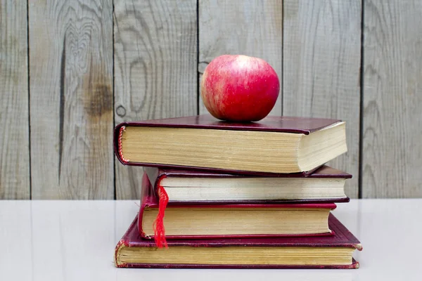 Beyaz bir arka plan üzerinde apple ile eski kitaplar.