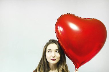 Kalp şekli hava balonu gri arka plan üzerinde olan güzel kadın. Sevgililer günü.