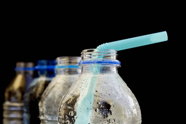 Su siyah arka plan üzerine pipet ile plastik şişe. Yakın çekim.