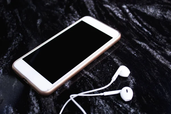 Mermer zemin üzerine kulaklıklar ile Smartphone.
