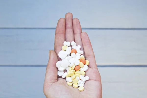 Colorful pills and medicines in the woman hand.
