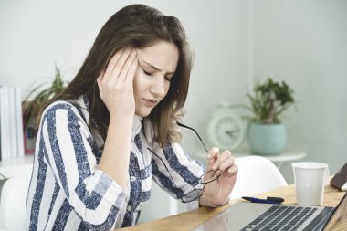 Genç iş kadını ofiste bir baş ağrısı var.