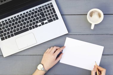 Eller kadın laptop ve kahve Kupası ile boş kağıt yazma.