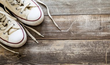 Ahşap arka planda beyaz tuval ayakkabı. Boşluk Kopyala.