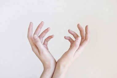 Kadın elleri gri arka plan üzerinde izole bir şey tutan.