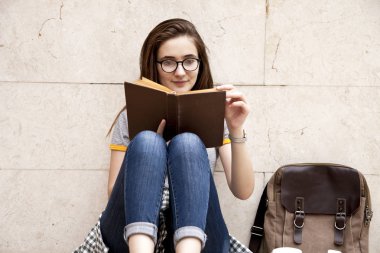 Dışarıda kitap okuyan genç bir kız öğrenci..