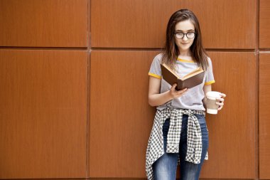 Dışarıda kitap okuyan genç bir kız öğrenci..