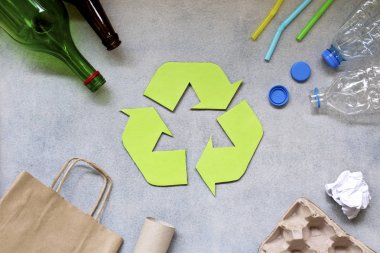 Geri dönüşüm sembolü ve gri arka plan üzerinde farklı çöp. Üstte görüntü.