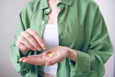 Bir kadın avucunun içinden takviyeler alır.