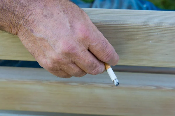 old man smokes with his wrinkled hands. old, wrinkled hands